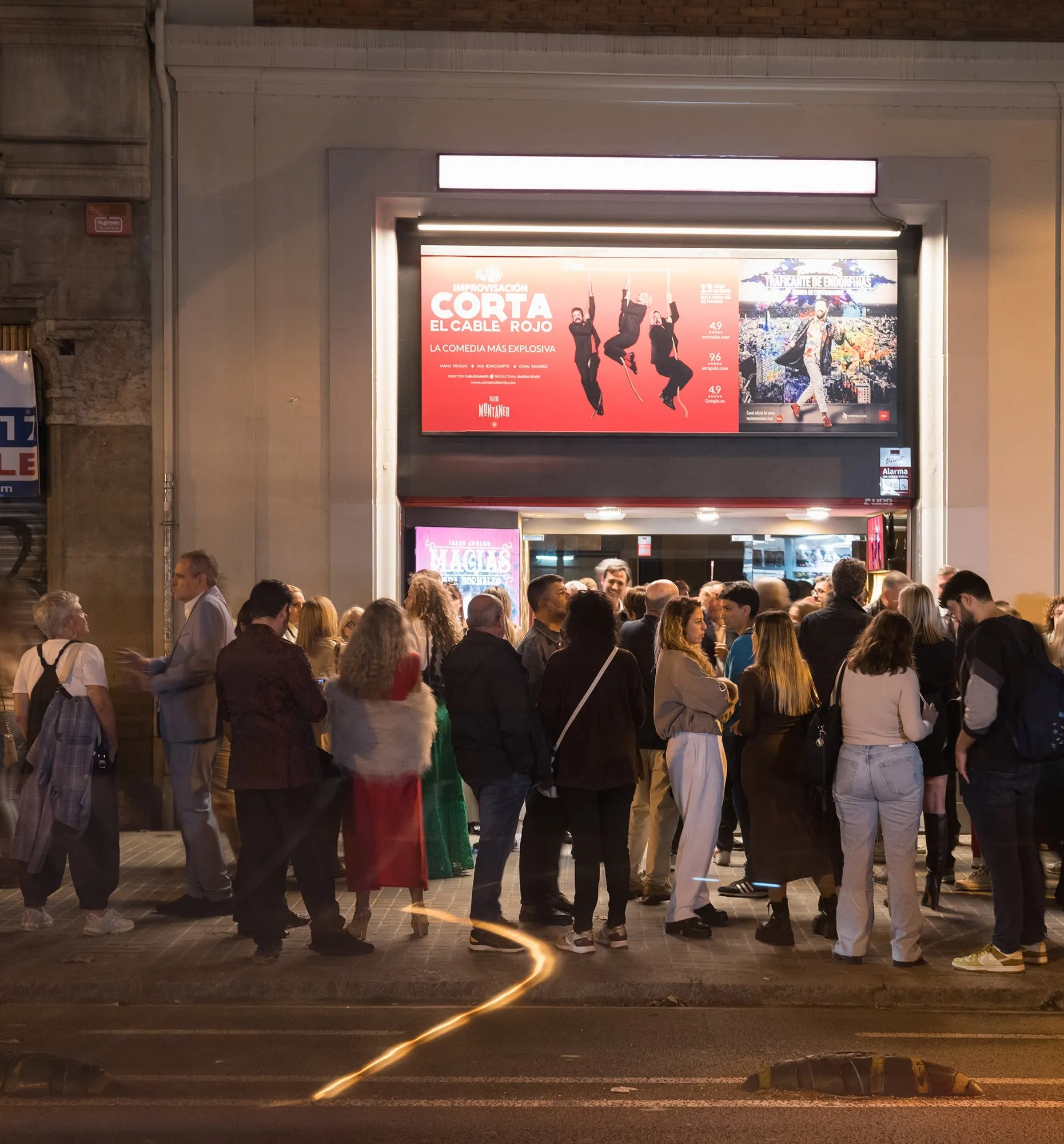 Cua de públic de nit a la façana del Teatre Muntaner